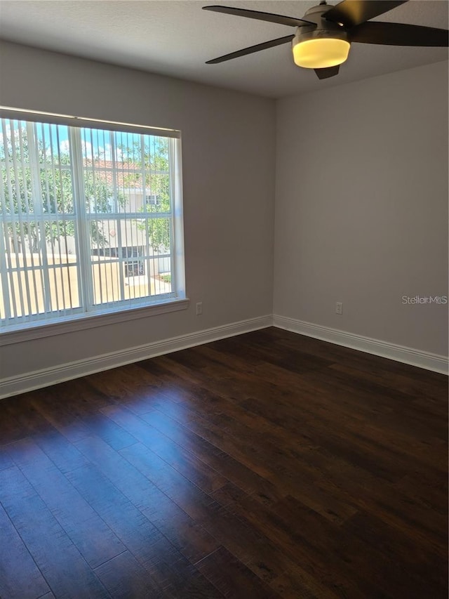 unfurnished room featuring dark wood-type flooring and ceiling fan