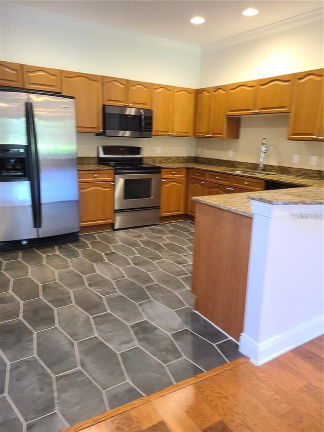 kitchen featuring dark hardwood / wood-style floors, crown molding, appliances with stainless steel finishes, and sink