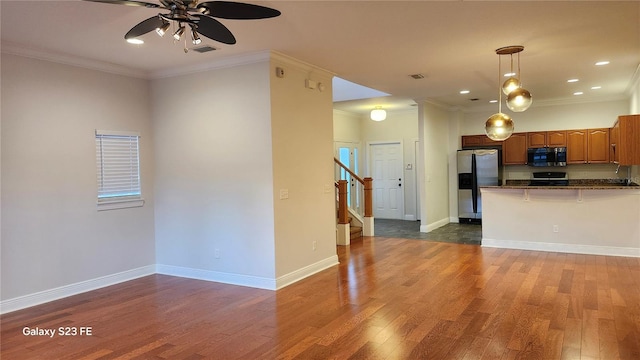 kitchen featuring stainless steel appliances, dark hardwood / wood-style floors, a kitchen breakfast bar, decorative light fixtures, and kitchen peninsula