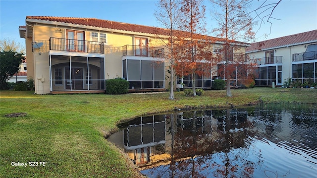 rear view of house featuring a yard and a water view