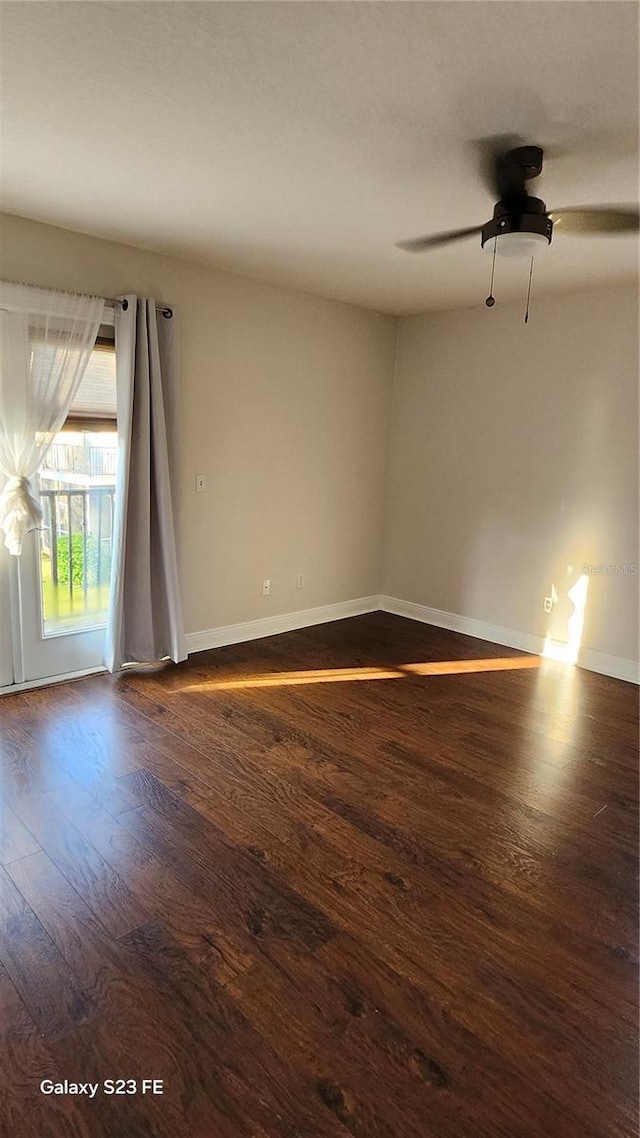 unfurnished room with dark hardwood / wood-style flooring and ceiling fan