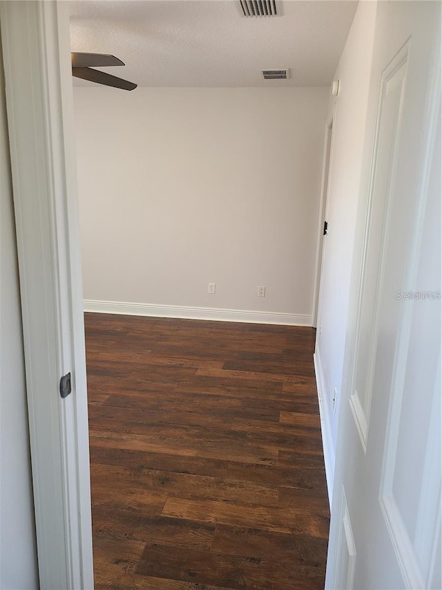 spare room featuring dark hardwood / wood-style flooring and ceiling fan