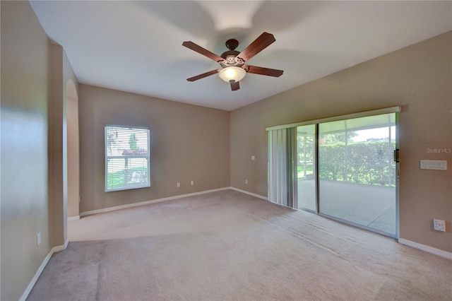 carpeted empty room featuring a wealth of natural light and ceiling fan