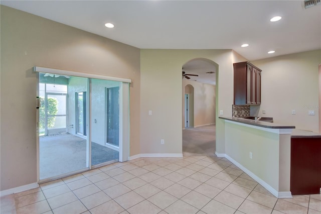 kitchen featuring tasteful backsplash, ceiling fan, and light tile patterned floors