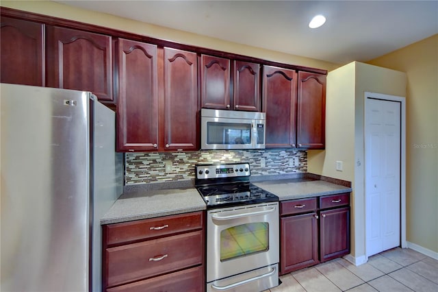 kitchen with stainless steel appliances, light tile patterned floors, and decorative backsplash