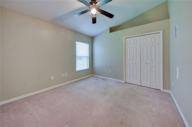 unfurnished bedroom with lofted ceiling, light carpet, a closet, and ceiling fan