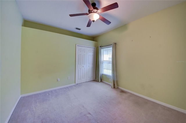 unfurnished bedroom featuring light colored carpet, a closet, and ceiling fan