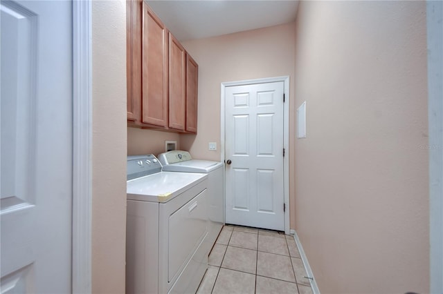 washroom with independent washer and dryer, cabinets, and light tile patterned floors