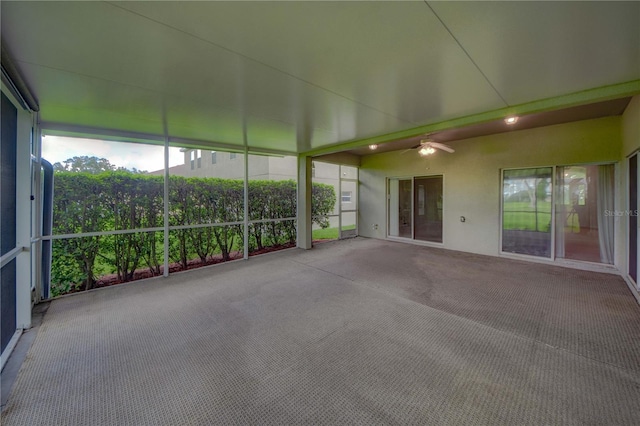 unfurnished sunroom with ceiling fan