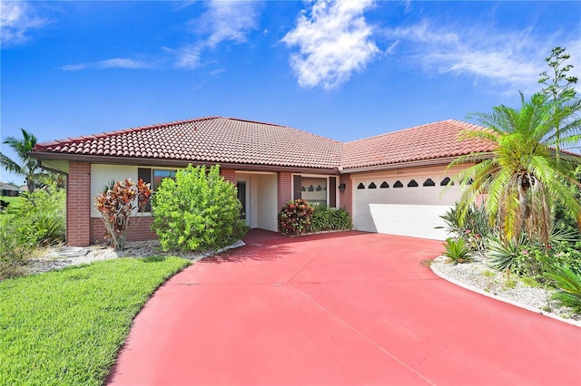 view of front of home with brick siding, driveway, a tiled roof, and an attached garage