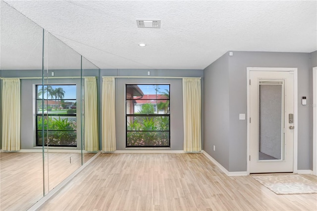 interior space with light wood-type flooring and a textured ceiling