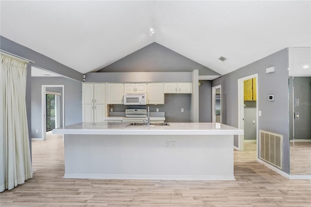 kitchen featuring high vaulted ceiling, light wood-type flooring, white appliances, and white cabinets