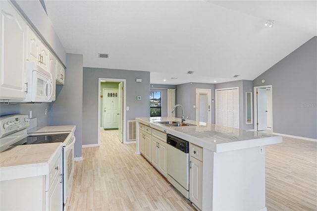 kitchen featuring white appliances, light countertops, a sink, and light wood finished floors