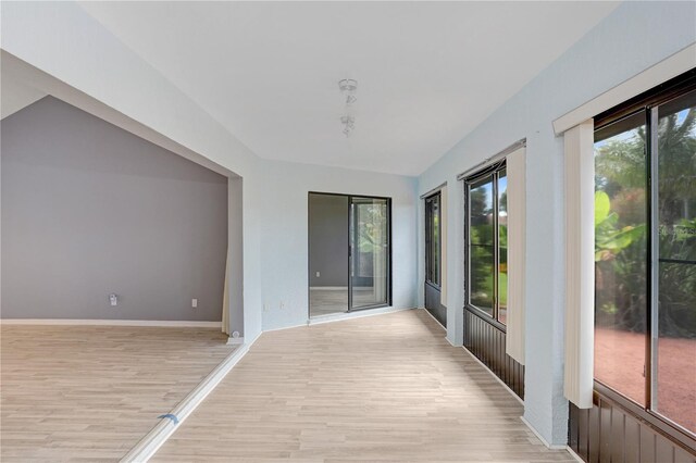 hall featuring a healthy amount of sunlight and light hardwood / wood-style floors