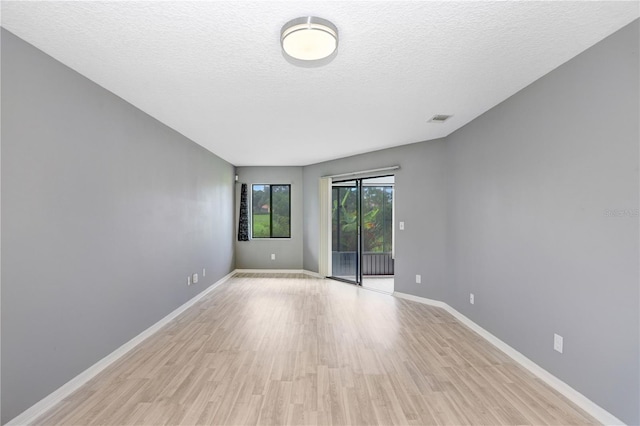 spare room featuring a textured ceiling and light wood-type flooring