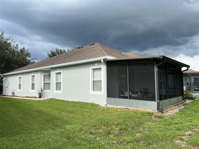 view of side of property with a lawn and a sunroom