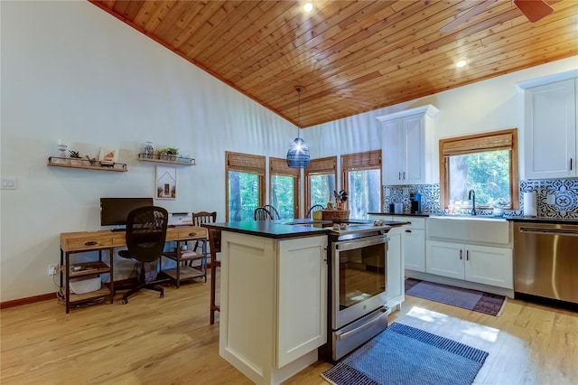 kitchen with sink, hanging light fixtures, white cabinets, and appliances with stainless steel finishes