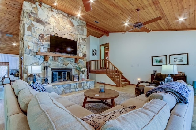 living room with ceiling fan, high vaulted ceiling, wood-type flooring, a stone fireplace, and wooden ceiling