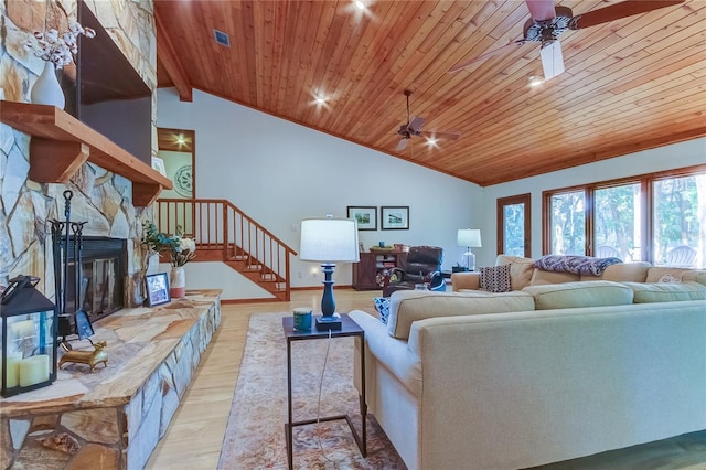 living room with wood ceiling, vaulted ceiling, ceiling fan, a fireplace, and light hardwood / wood-style floors