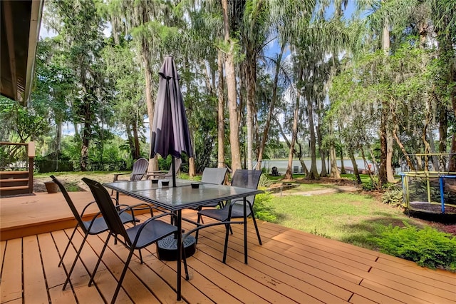 deck with a yard and a trampoline