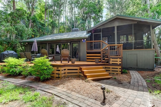 back of house with a wooden deck and a sunroom