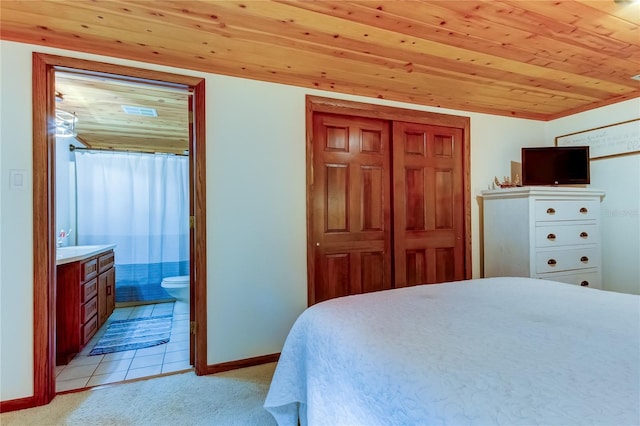 carpeted bedroom with wood ceiling, ensuite bath, and a closet