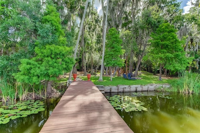 view of dock featuring a lawn and a water view