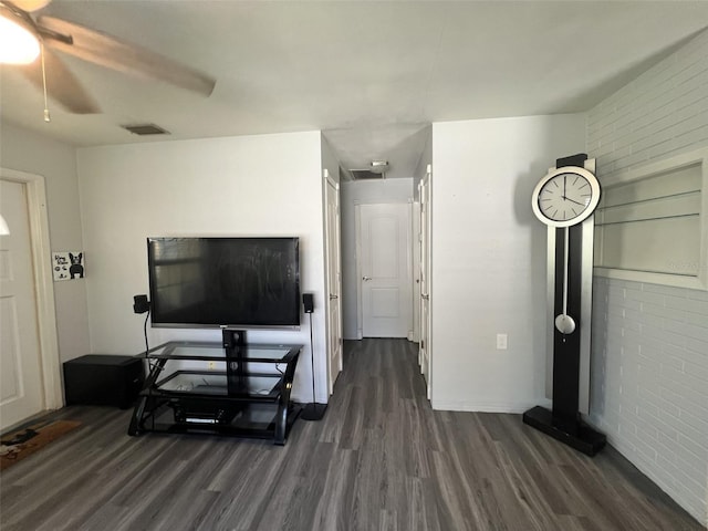 living room featuring ceiling fan, brick wall, and dark hardwood / wood-style floors