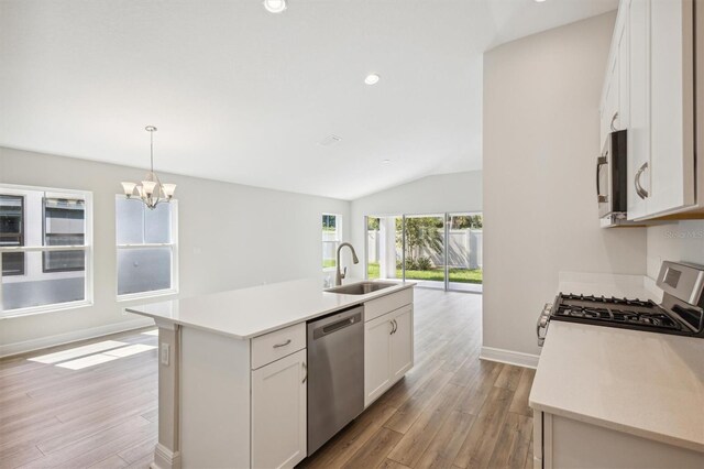 kitchen with stainless steel appliances, a kitchen island with sink, white cabinets, sink, and light hardwood / wood-style flooring