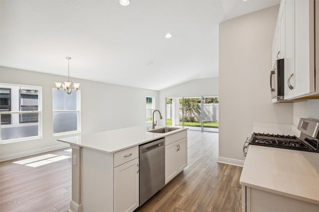 kitchen with a kitchen island with sink, stainless steel appliances, light countertops, white cabinetry, and a sink