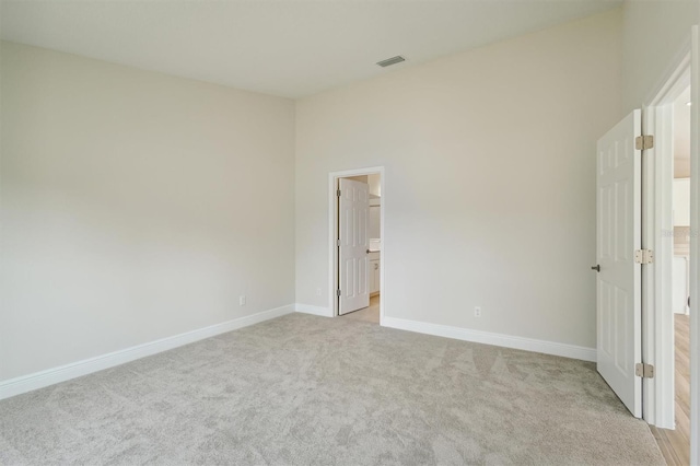 unfurnished bedroom with light carpet, visible vents, and baseboards