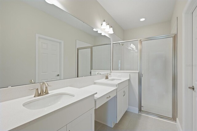 bathroom with a shower with shower door, tile patterned floors, and double vanity