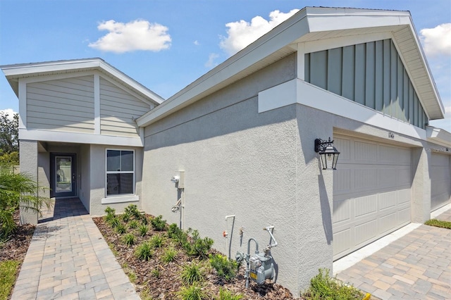 exterior space with an attached garage and stucco siding