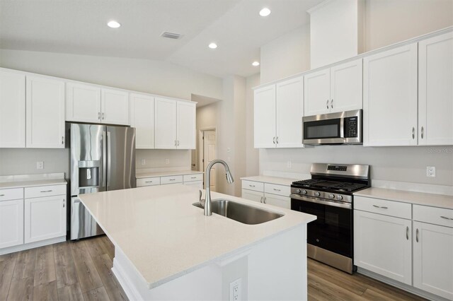 kitchen with appliances with stainless steel finishes, light wood-type flooring, and an island with sink