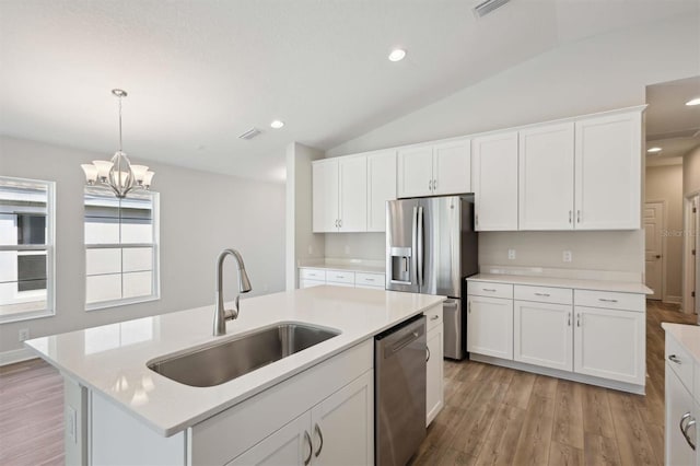 kitchen with appliances with stainless steel finishes, sink, an island with sink, and white cabinetry