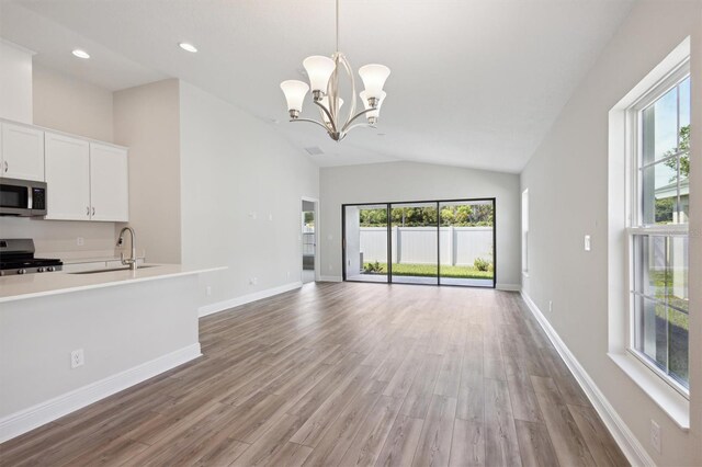 interior space featuring sink, stainless steel appliances, light hardwood / wood-style floors, and white cabinetry