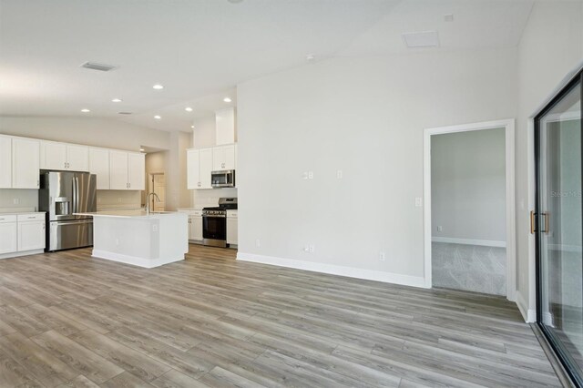 kitchen featuring light hardwood / wood-style flooring, white cabinetry, a kitchen island with sink, high vaulted ceiling, and stainless steel appliances