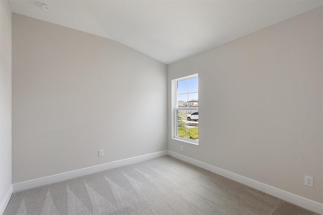 spare room with carpet and lofted ceiling