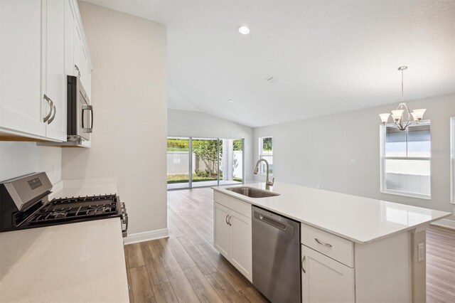 kitchen featuring stainless steel appliances, an island with sink, sink, white cabinetry, and light hardwood / wood-style flooring