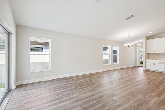 unfurnished living room with visible vents, light wood-style floors, vaulted ceiling, baseboards, and an inviting chandelier