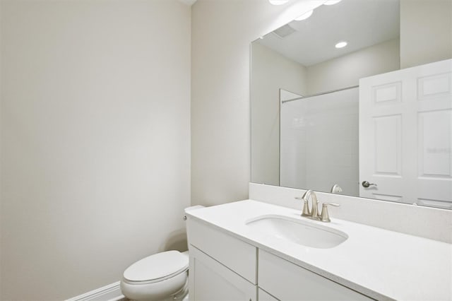 full bath featuring tiled shower, vanity, toilet, and baseboards