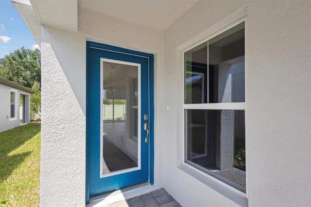 view of exterior entry featuring stucco siding