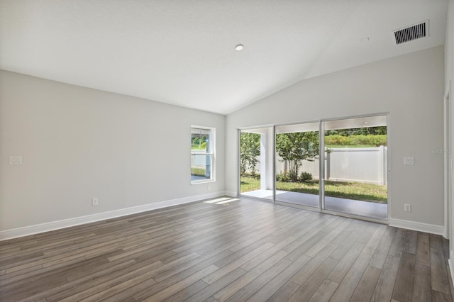 unfurnished room featuring lofted ceiling and wood-type flooring