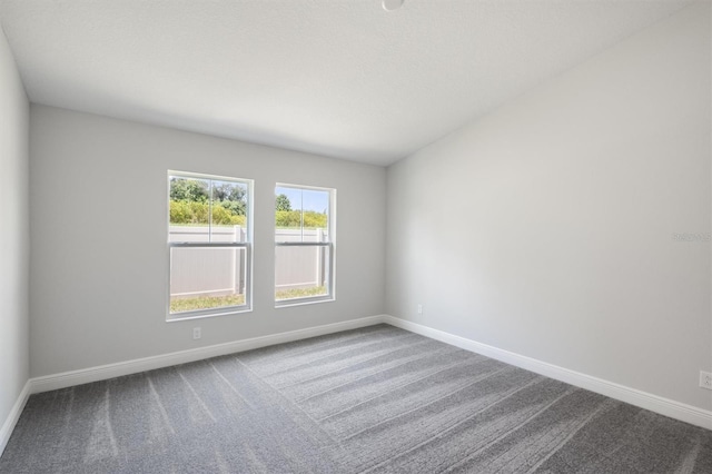 carpeted spare room with baseboards