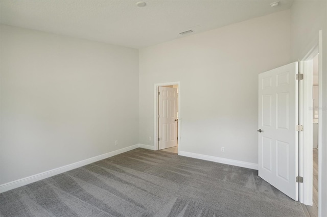 unfurnished bedroom featuring carpet flooring and a high ceiling