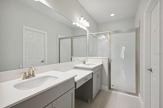 full bath with a stall shower, two vanities, a sink, and tile patterned floors