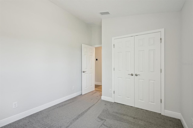 unfurnished bedroom featuring a closet, carpet flooring, visible vents, and baseboards