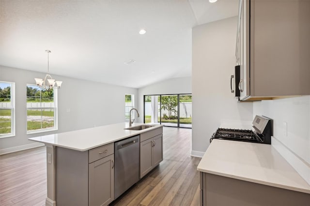 kitchen with light hardwood / wood-style flooring, gas stove, stainless steel dishwasher, gray cabinets, and an island with sink