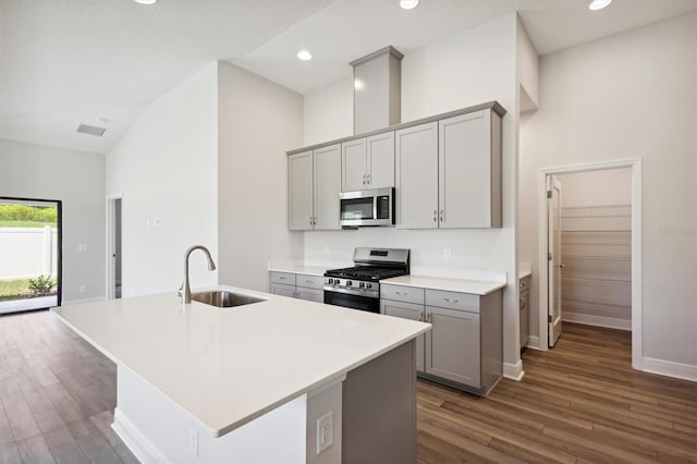 kitchen featuring dark wood-type flooring, stainless steel appliances, high vaulted ceiling, gray cabinets, and sink