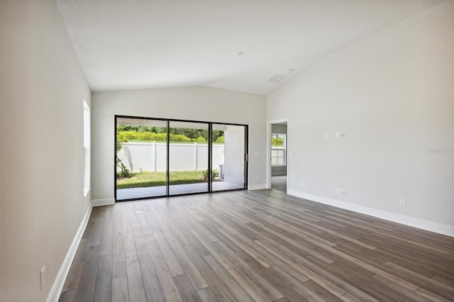 unfurnished room featuring lofted ceiling, baseboards, and wood finished floors